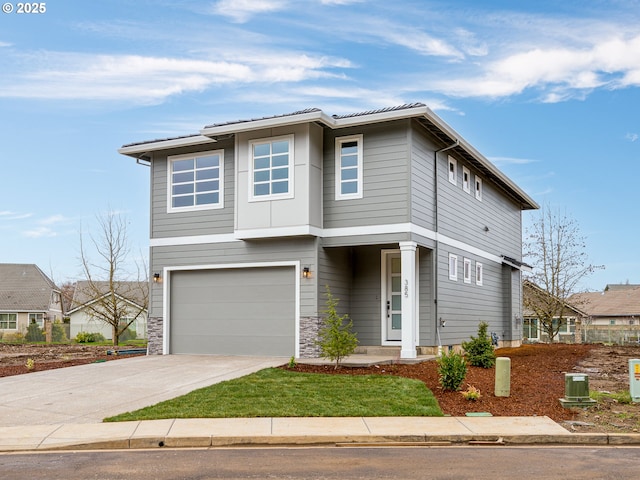 view of front of house with stone siding, an attached garage, and concrete driveway