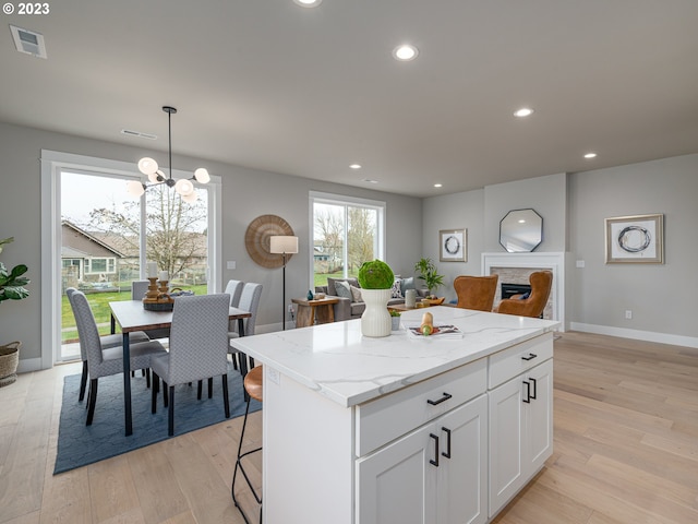 kitchen with light wood finished floors, visible vents, recessed lighting, and a center island