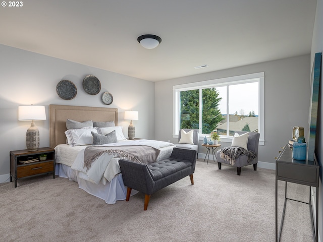 bedroom with visible vents, light colored carpet, and baseboards