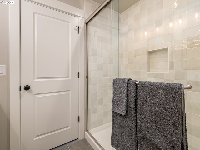 bathroom with tile patterned floors and a stall shower