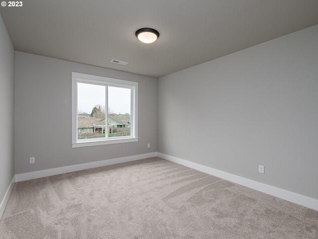 empty room with visible vents, carpet floors, and baseboards