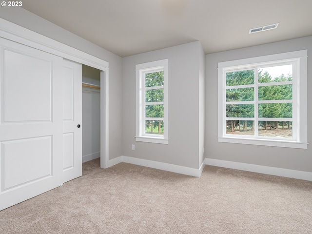 unfurnished bedroom with visible vents, light carpet, and baseboards