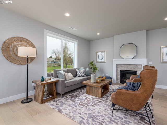 living area featuring visible vents, wood finished floors, recessed lighting, a fireplace, and baseboards