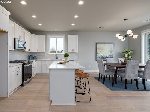 kitchen featuring a breakfast bar area, light wood-type flooring, visible vents, and stainless steel appliances