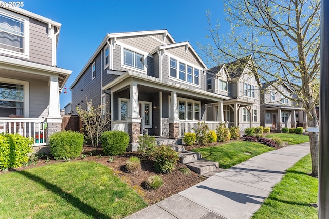 craftsman house featuring a porch, a front lawn, and stone siding