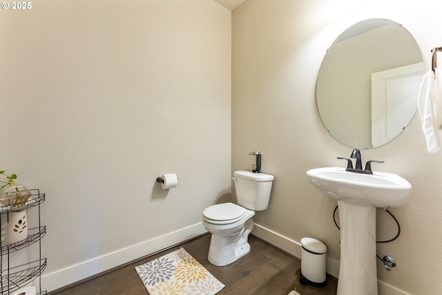 bathroom featuring a sink, toilet, wood finished floors, and baseboards
