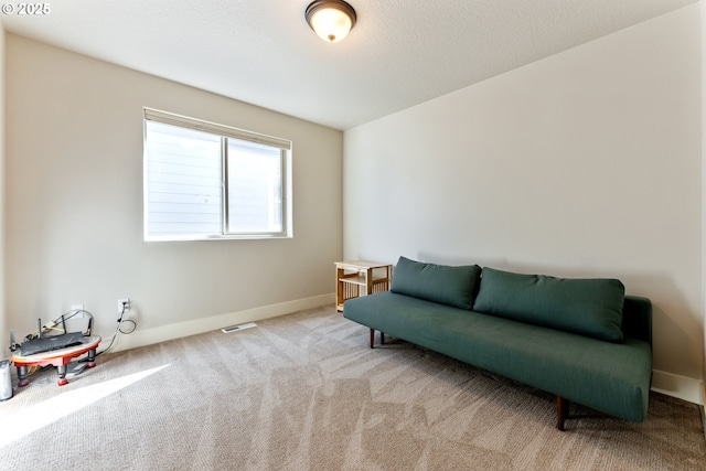 sitting room with baseboards, visible vents, and carpet
