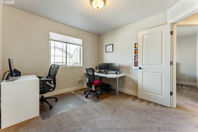 carpeted office featuring visible vents and baseboards
