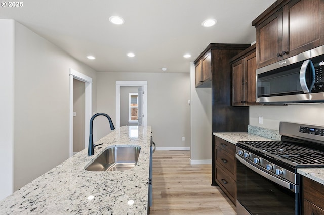 kitchen with a sink, dark brown cabinetry, stainless steel appliances, and recessed lighting