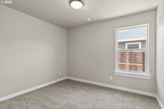 empty room with baseboards, visible vents, and carpet