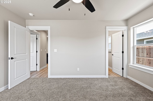 unfurnished bedroom featuring baseboards, a ceiling fan, and light colored carpet