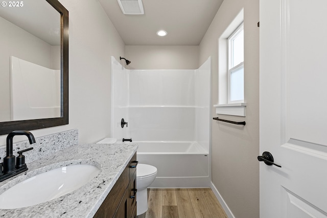 bathroom featuring toilet, wood finished floors, vanity, visible vents, and baseboards