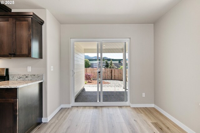 entryway featuring baseboards and light wood-style floors