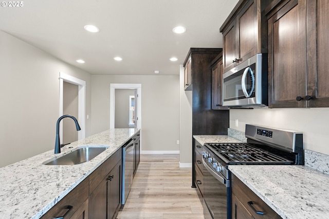 kitchen with dark brown cabinets, stainless steel appliances, recessed lighting, and a sink