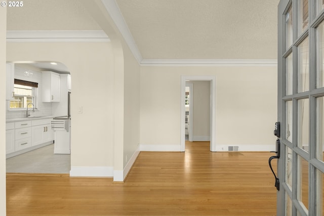 entryway featuring sink, light hardwood / wood-style flooring, and ornamental molding