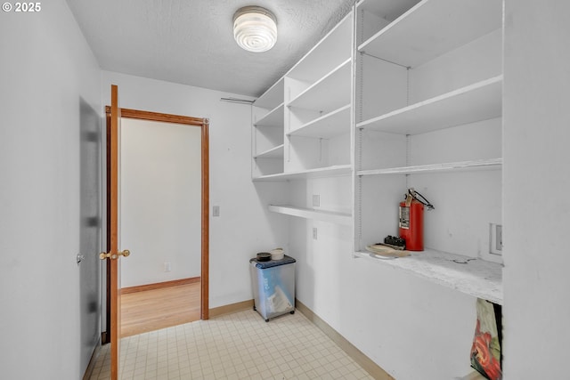 washroom with baseboards and a textured ceiling