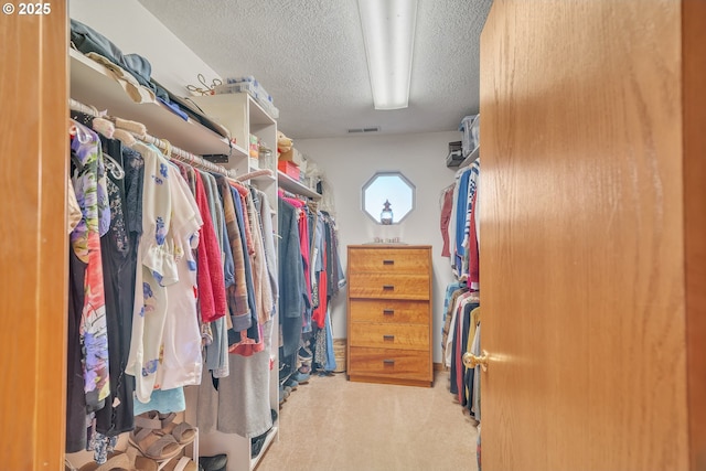 walk in closet featuring visible vents and carpet
