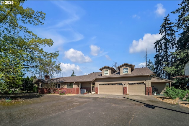 traditional-style home featuring a garage, brick siding, a shingled roof, and driveway