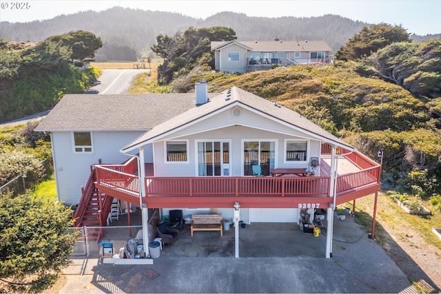 back of house featuring a garage and a deck with mountain view