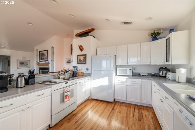 kitchen with lofted ceiling, sink, white cabinets, and white appliances