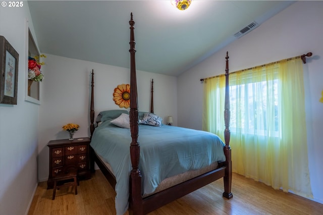 bedroom with vaulted ceiling and light wood-type flooring