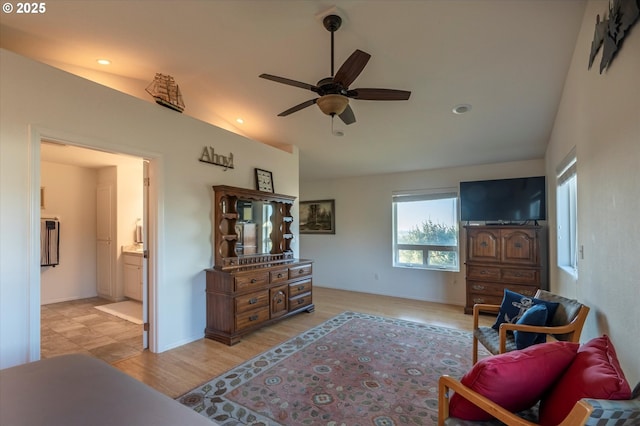 living area featuring lofted ceiling, light hardwood / wood-style floors, and ceiling fan