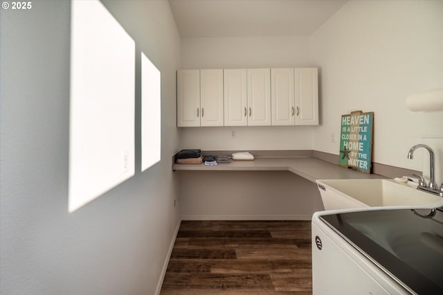 kitchen with sink, dark wood-type flooring, built in desk, and white cabinets