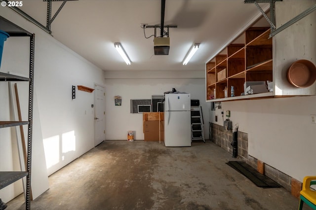 garage featuring white refrigerator and a garage door opener