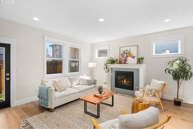 living room with recessed lighting, a fireplace, baseboards, and wood finished floors