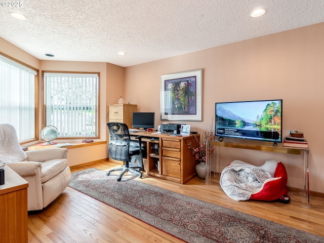 home office featuring light wood-style floors, recessed lighting, a textured ceiling, and baseboards