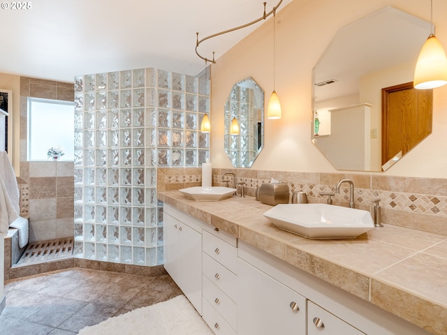 bathroom featuring a walk in shower, visible vents, a sink, and double vanity