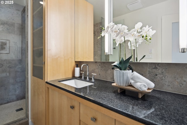 bathroom featuring vanity, tasteful backsplash, and a stall shower