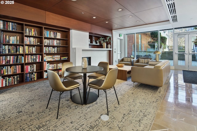 dining area with built in shelves, a wall of windows, recessed lighting, french doors, and a fireplace