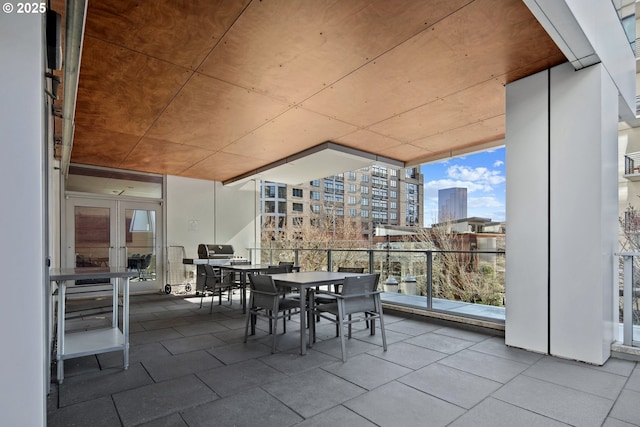 exterior space featuring outdoor dining space, french doors, a view of city, and a balcony