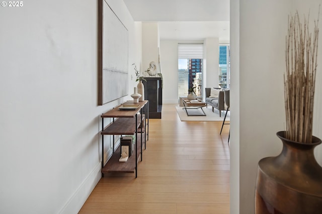 hallway with light wood finished floors and baseboards