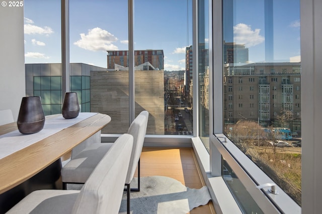 dining area featuring a healthy amount of sunlight, a wall of windows, and wood finished floors