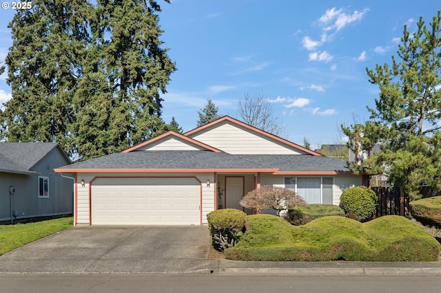 ranch-style house with a garage, concrete driveway, a shingled roof, and a front lawn