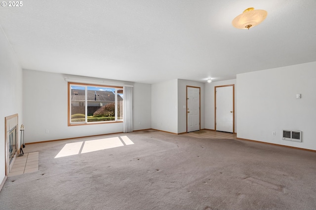 carpeted spare room with a textured ceiling, visible vents, and baseboards