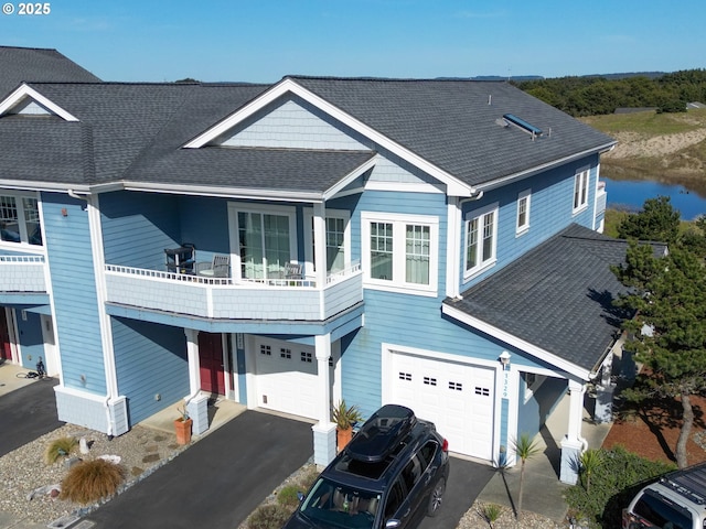 1327 Village Loop, Bandon, OR 97411 - view of front of home with a shingled roof, a garage, driveway, and a balcony