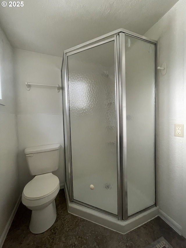 bathroom with a stall shower and toilet