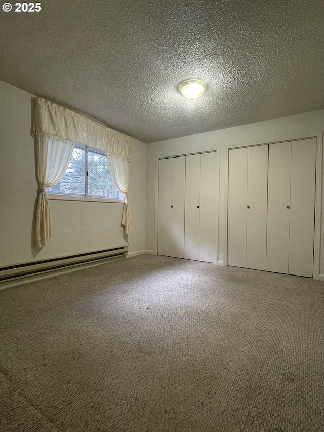 unfurnished bedroom featuring a textured ceiling, carpet, multiple closets, and a baseboard radiator