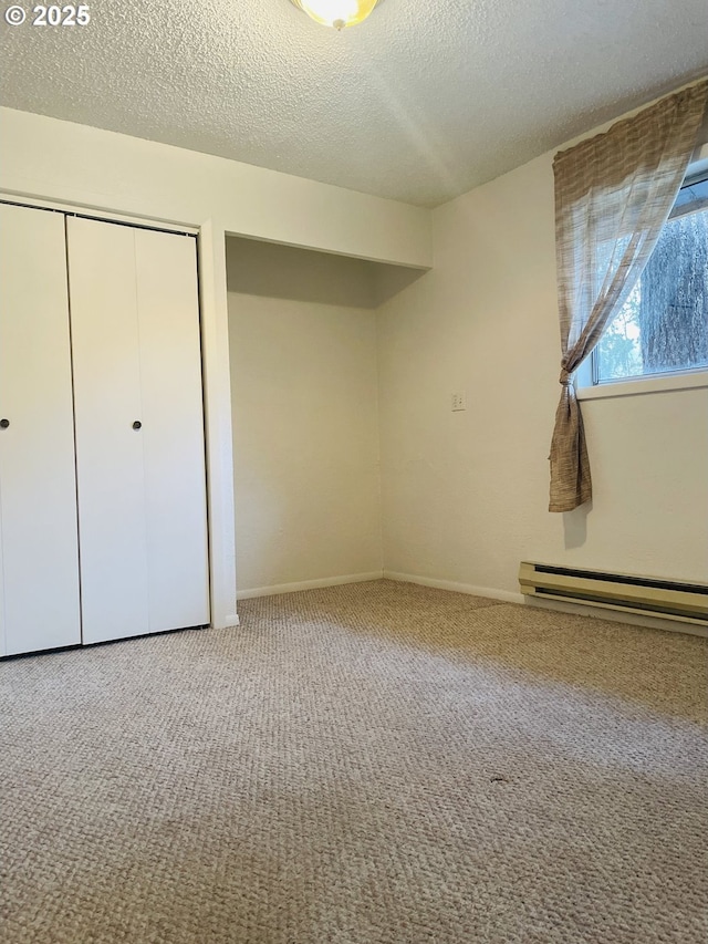 unfurnished bedroom featuring a closet, a baseboard radiator, a textured ceiling, and carpet floors