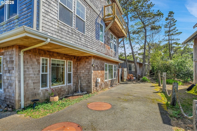 view of home's exterior with a patio and aphalt driveway