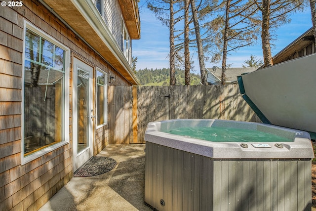 view of patio / terrace with fence and a hot tub