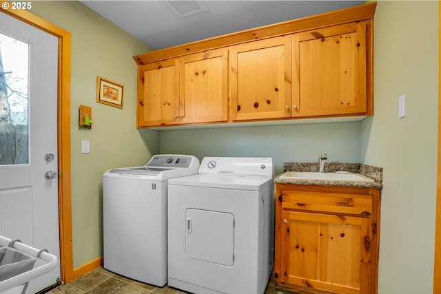 laundry room with cabinet space, washing machine and clothes dryer, a sink, baseboards, and visible vents