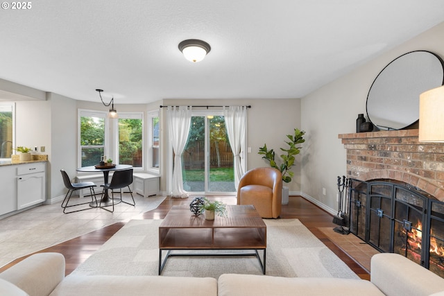 15421 SW Thurston Ln, Portland, OR 97224 - tiled living area with a fireplace and baseboards