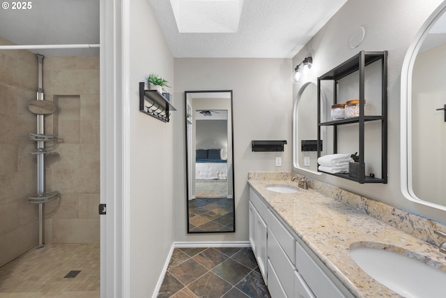 15421 SW Thurston Ln, Portland, OR 97224 - bathroom featuring baseboards, double vanity, tiled shower, a skylight, and a textured ceiling