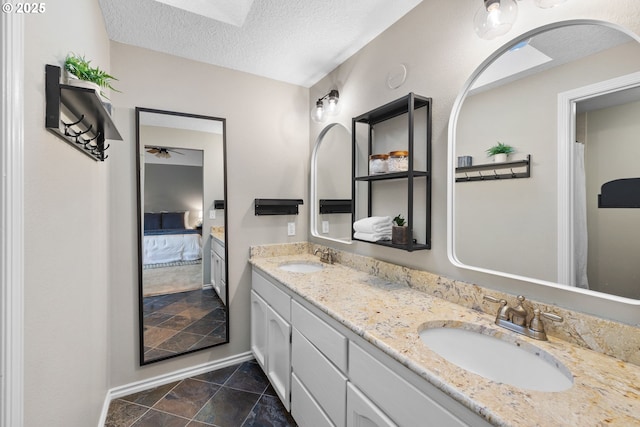15421 SW Thurston Ln, Portland, OR 97224 - ensuite bathroom featuring double vanity, a textured ceiling, a ceiling fan, and baseboards