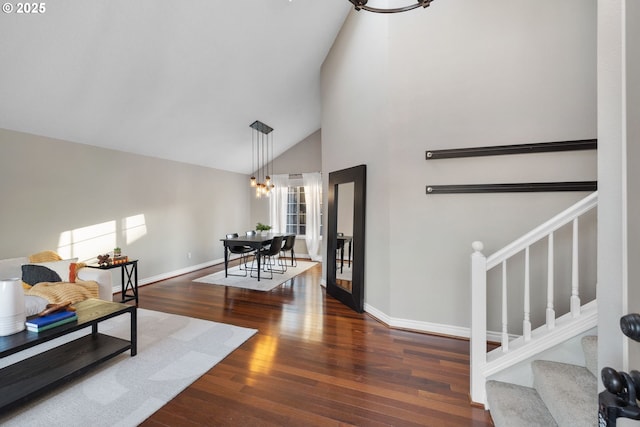 15421 SW Thurston Ln, Portland, OR 97224 - living room featuring a chandelier, stairway, wood finished floors, high vaulted ceiling, and baseboards