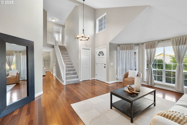 15421 SW Thurston Ln, Portland, OR 97224 - living area featuring high vaulted ceiling, a chandelier, stairs, healthy amount of natural light, and wood finished floors